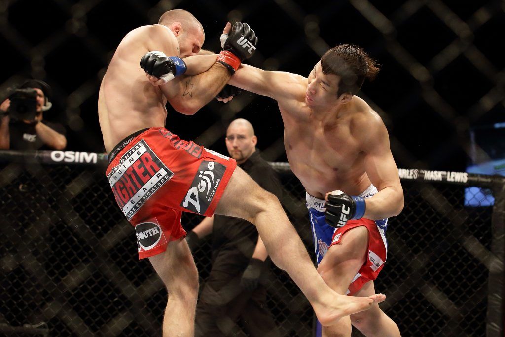 SINGAPORE - JANUARY 04: Tarec Saffiedine (L) fights Lim Hyun Gyu during their UFC Fight Night Singapore welterweight bout at Marina Bay Sands on January 4, 2014 in Singapore. (Photo by Suhaimi Abdullah/Getty Images)