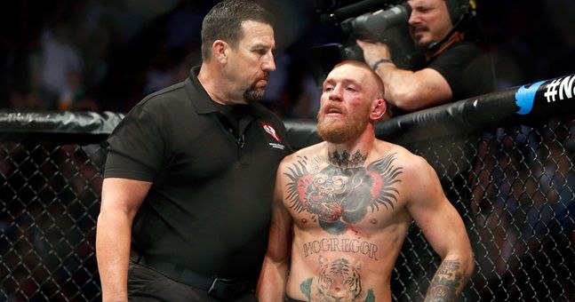 LAS VEGAS, NV - AUGUST 20:  Referee John McCarthy (L) makes sure Conor McGregor goes back to his corner at the end of a round of his welterweight rematch against Nate Diaz at the UFC 202 event at T-Mobile Arena on August 20, 2016 in Las Vegas, Nevada. McGregor won by majority decision.  (Photo by Steve Marcus/Getty Images)