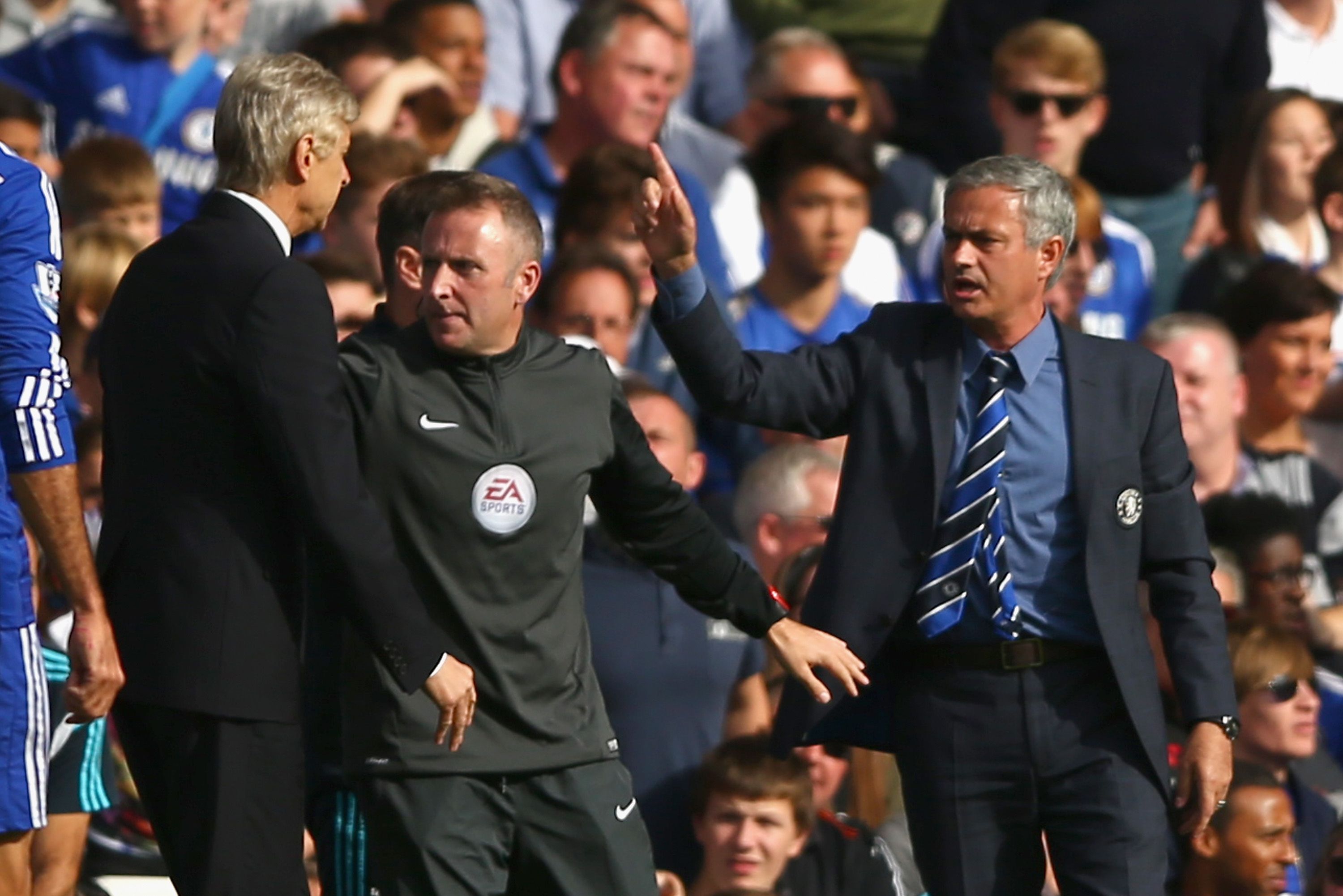 LONDON, ENGLAND - OCTOBER 05: Fourth Official Jonathan Moss comes between Managers Arsene Wenger of Arsenal and Jose Mourinho manager of Chelsea during the Barclays Premier League match between Chelsea and Arsenal at Stamford Bridge on October 4, 2014 in London, England. (Photo by Paul Gilham/Getty Images)